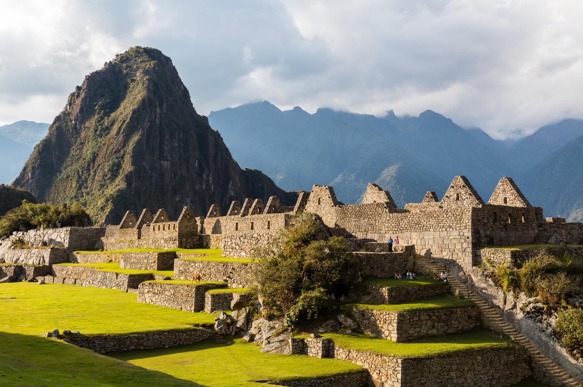 Die Steinbauten und Terrassen von Machu Picchu mit dem Gipfel des Huayna Picchu im Hintergrund
